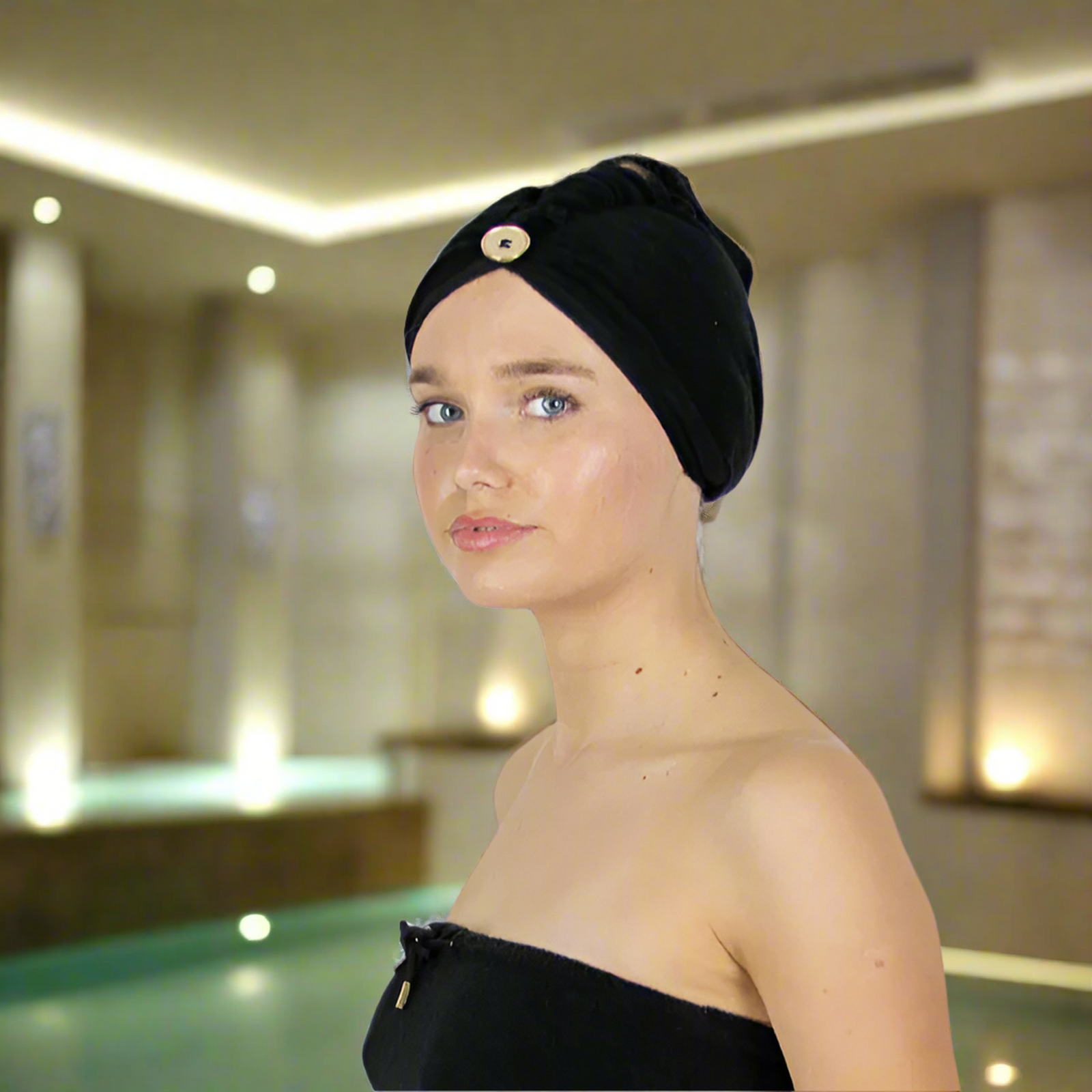 Woman wearing the black Dry Dolly Classic Head Towel beside an indoor pool